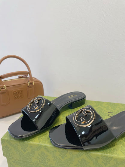 SLIDE SANDALS IN BLACK GLOSSY SHEEPSKIN ENAMELLED ROUND INTERLOCKING G